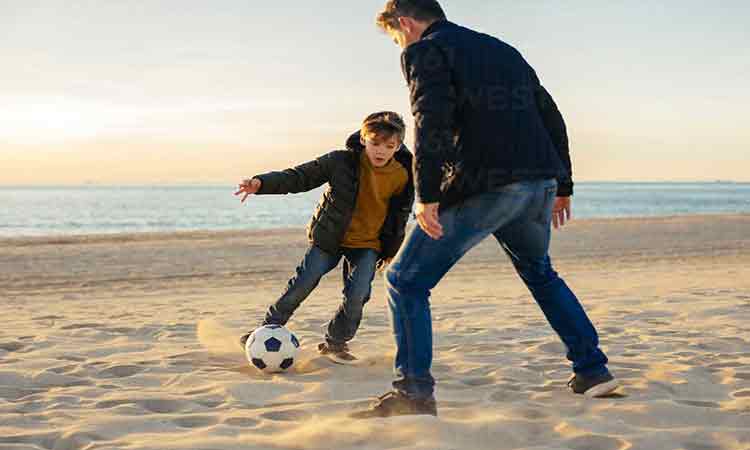 أب يلعب مع ابنه الكرة